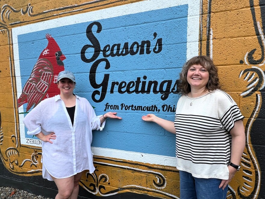 Amanda Lewis and Amanda Page pose next to a painting on a building in Portsmouth.