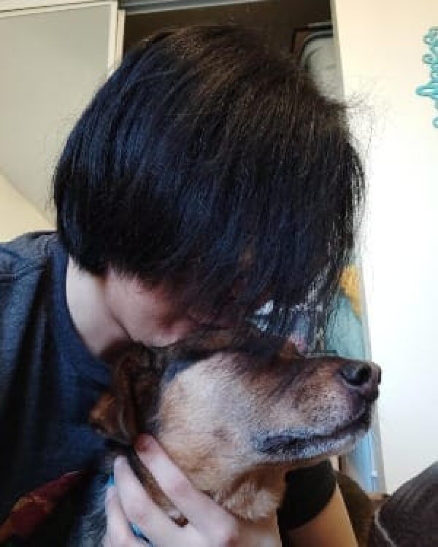 Jeron embraces his dog.