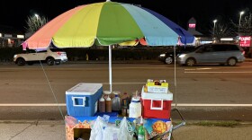 Unpermitted food cart with a colorful umbrella.