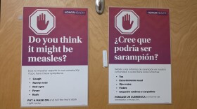  A sign asking about measles symptoms on a hospital door.