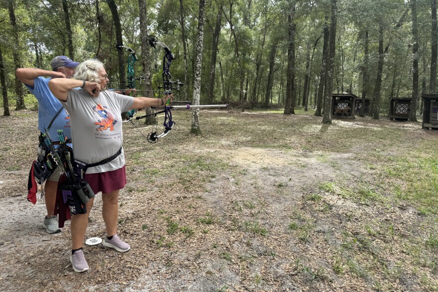 Jerry and Patty Hoppe shoot compound release. There are other shooting styles represented in the games. (Corey Fiske/WUFT News)