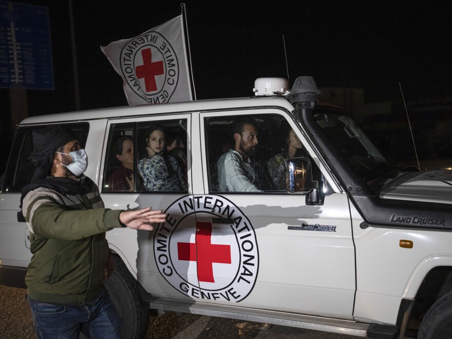 A Red Cross vehicle carrying Israeli hostages drives by at the Gaza Strip crossing into Egypt in Rafah on Saturday, Nov. 25, 2023.