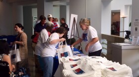 people gathered at one of may exhibition tables