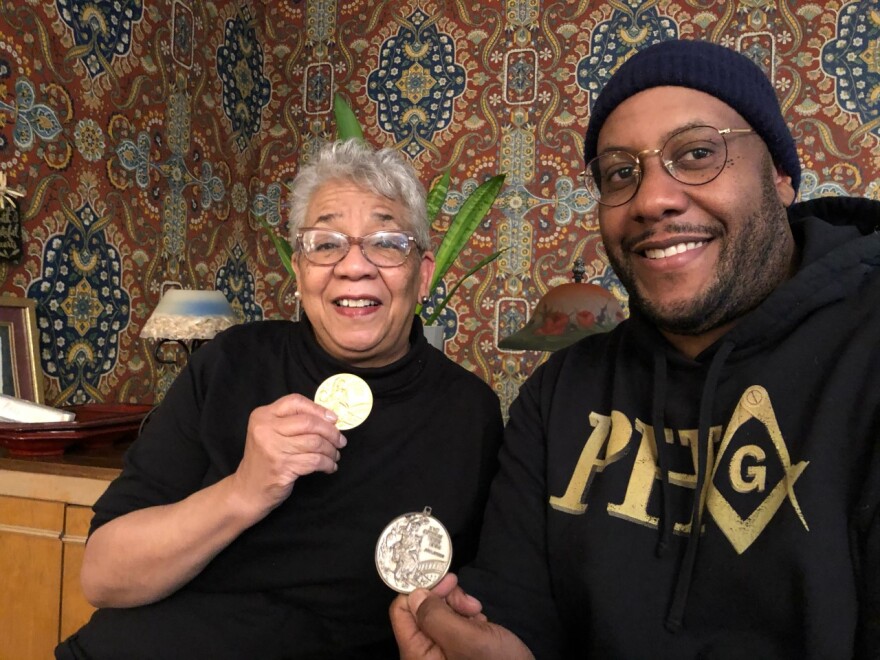 Jeune Drayton and her son Walter McCormick hold up Paul Drayton's Olympic medals.