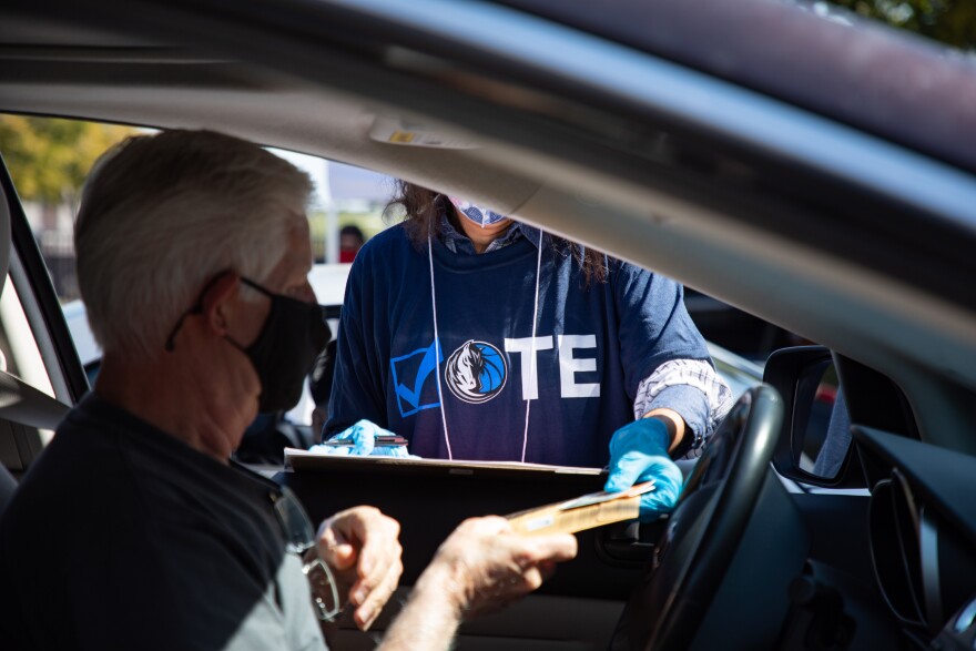 James Murrell hands in his voter registration and I.D. to a Dallas Elections Office worker on Monday.