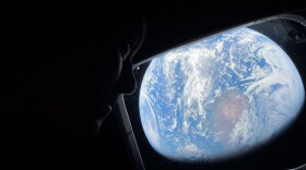 In this photo provided by NASA, Commander Reid Wiseman looks at the Earth from a window aboard the Orion spacecraft Integrity during the Artemis II mission en route to the moon on Thursday, April 2, 2026. (NASA via AP)