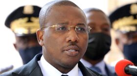 Claude Joseph speaks during a press conference Friday in Port-au-Prince. The country's interim prime minister says he's optimistic about forming a unity government.
