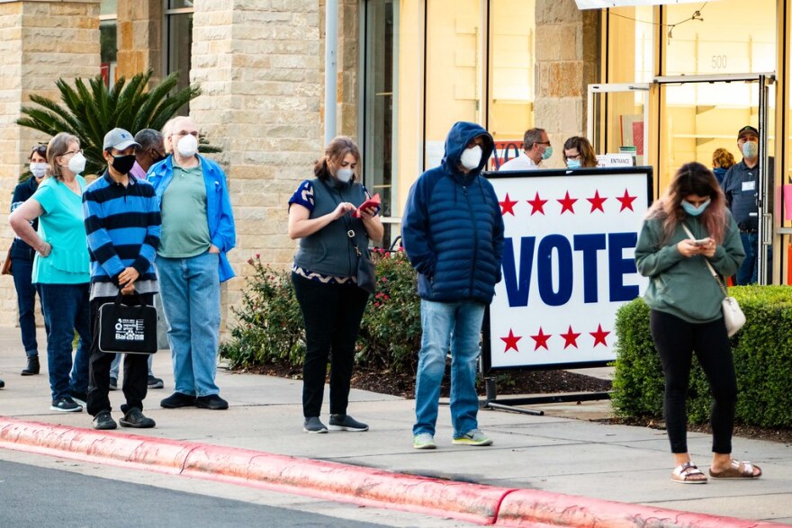 Voters wear masks in line at Southpark Meadows in South Austin on the first day of early voting in Texas.