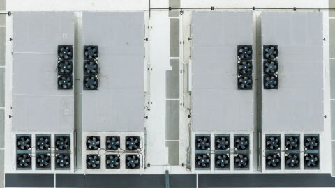 An aerial image directly above the roof of a data center. The structure contains rows of fans. 