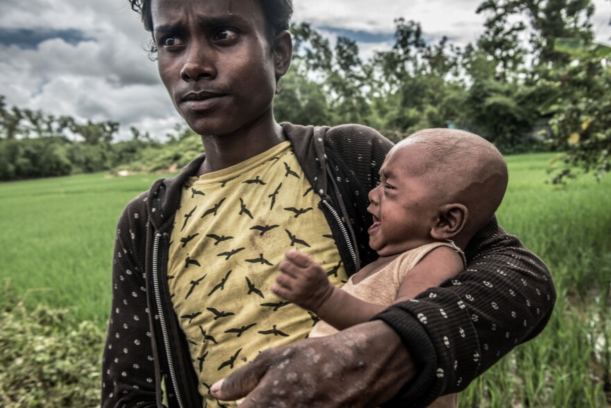 Abdul Rahman, 21, cares for his four-month-old daughter Sangida. Her mother was shot dead by soldiers in Myanmar while trying to flee to Bangladesh.