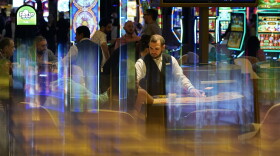 In this June 24, 2021 photo, a dealer distributes cards to gamblers at Resorts World Las Vegas in Las Vegas.
