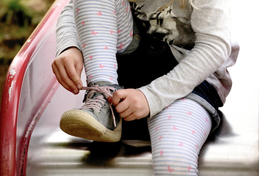 A child ties a shoe