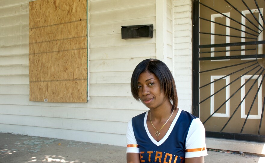 Lanita Carter sits on the porch of the home she purchased in Detroit.