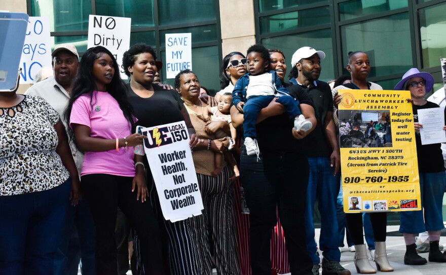 There are about a dozen Black people standing with posters that say "Save My Future" and promote a local worker union.