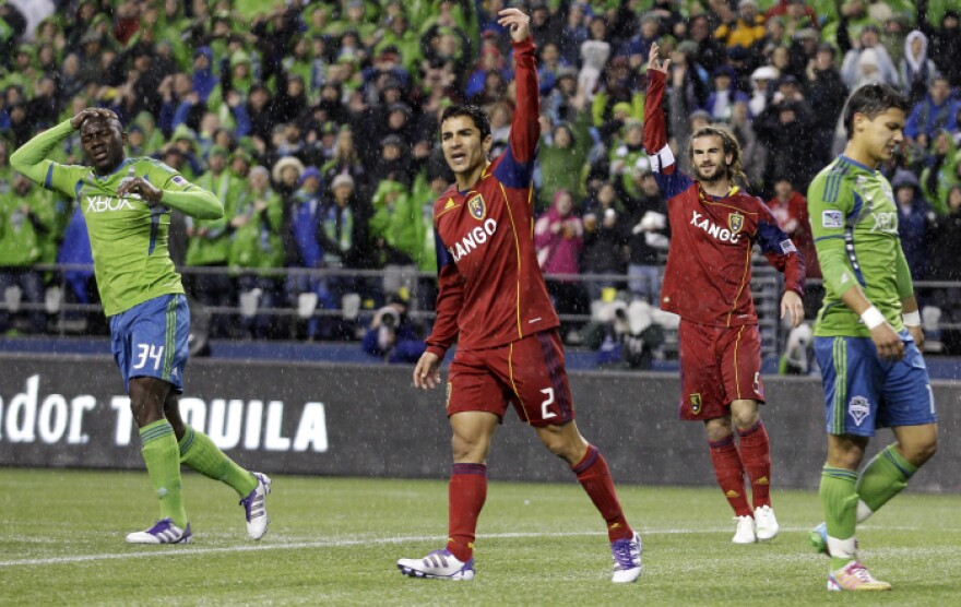 Real Salt Lake's Tony Beltran (2) and Kyle Beckerman, center, celebrate a play as Seattle Sounders' Jhon Kennedy Hurtado, left, and Fredy Montero, second from right, react. The Seattle Sounders won the game 2-0, but were knocked out of the playoffs.