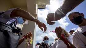 Many Cuban-Americans are asking the Biden Administration to solve the problem of the Cuban Family Reunification Parole Program. The program has been paused indefinitely since 2017. In this photo Cuban-Americans pass out prayer beads at the Ermita de la Caridad shrine in Miami, where they recently gathered to pray and call for a solution to their immigration problems.