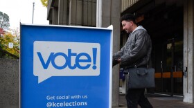 A person drops off a ballot in a ballot box. 