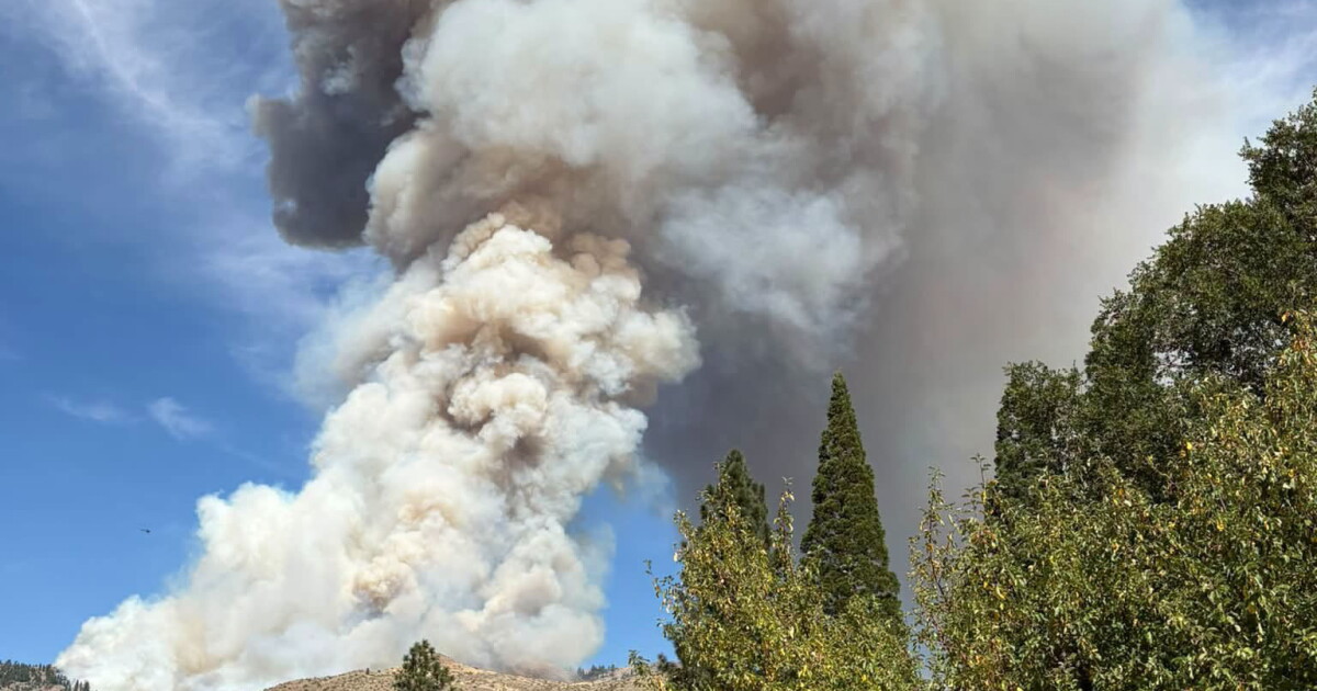 Wildfire smoke fills the sky behind rolling hills