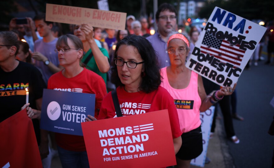 Advocates of stricter gun legislation hold a candlelight vigil for victims of recent mass shootings outside the headquarters of the National Rifle Association on Monday in Fairfax, Va.