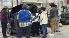 a group of students standing around an EV engine