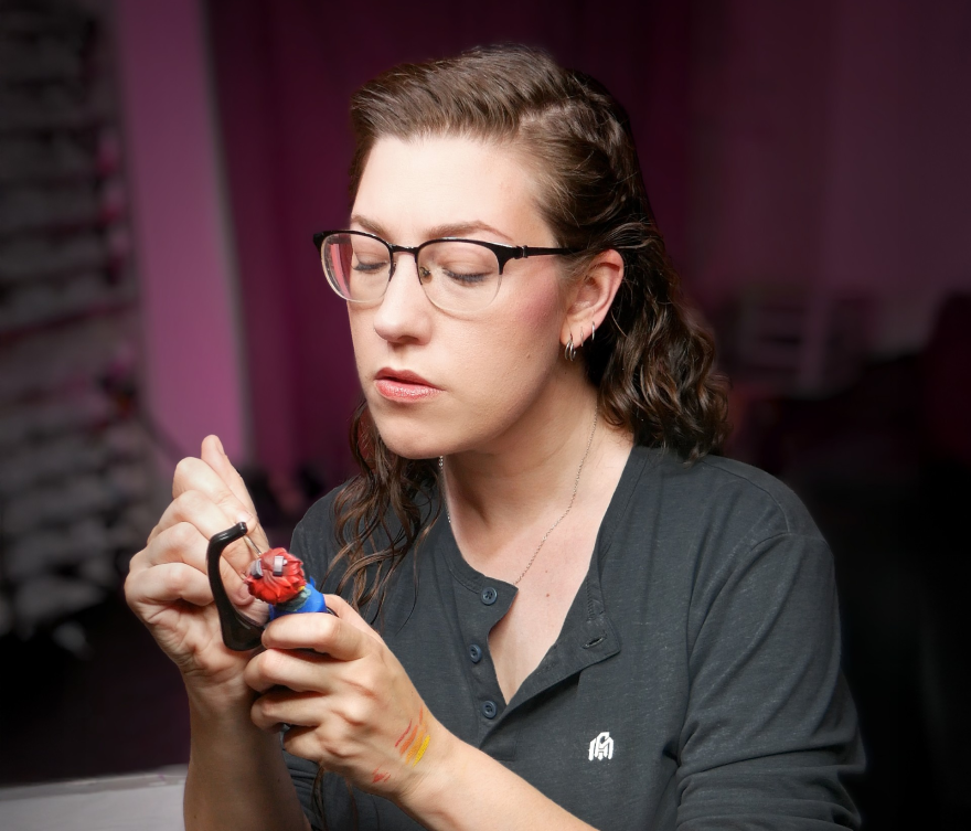 A woman paints a mini figurine