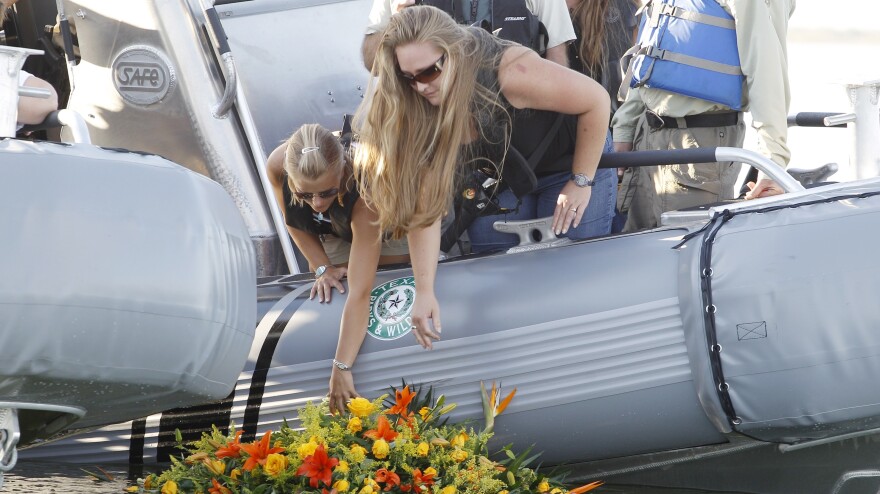 Tiffany Hartley (left) and family members lay a wreath near where her husband, David, was shot on Falcon Lake in 2010. Authorities say the shooting was the work of a Mexican drug cartel. David's body has never been found.