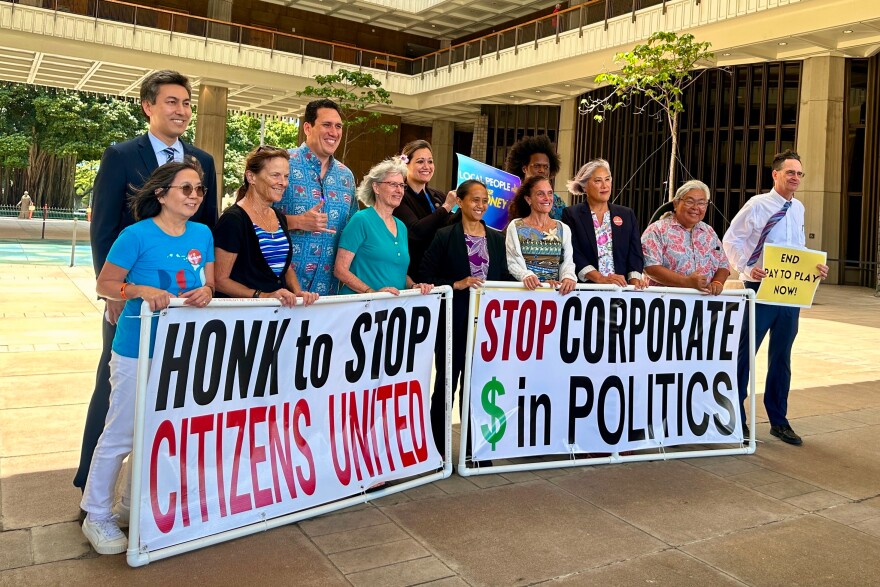 Hawaii lawmakers and activists pose for a photo after discussing a bill that seeks to limit corporate money in politics in Honolulu on Thursday, April 23, 2026.