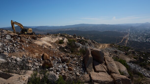 Construction crews work on a new border wall segment on Kuuchamaa Mountain, Friday, April 24, 2026, seen from Tecate, Mexico. (AP Photo/Gregory Bull)