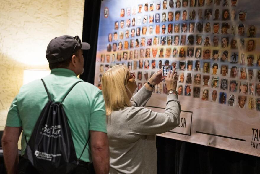 Military suicide survivors look at a photo montage of relatives who died of suicide. 