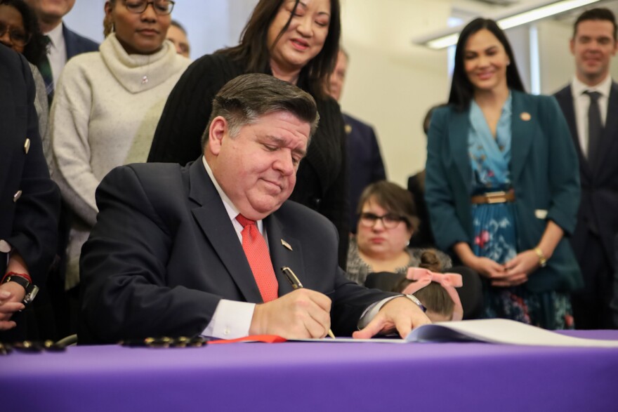 Gov. JB Pritzker signs the Dignity in Pay Act at a ceremony in Chicago on Tuesday, Jan. 21, 2025.
