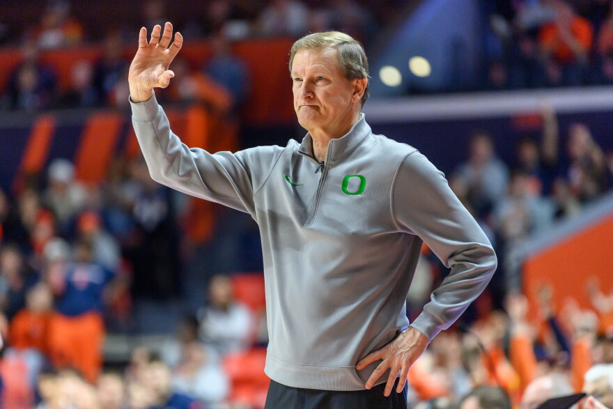 Oregon head coach Dana Altman stands with a hand in the air.