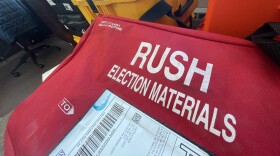 Boxes and crates in a room. One says "election materials"