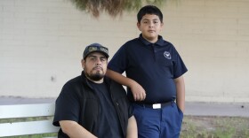 Aaron Galaz and his son pose for a photo on Wednesday, Oct. 18, 2023 in Phoenix. Aaron Galaz said his son is enrolled in a program that uses taxpayer funds to pay for private-school tuition in part so his son could be challenged more in class. At least four states that have made most children eligible for taxpayer-funded scholarships to private schools are seeing more families using the programs than planned. That could cost taxpayers, but it's early to know the exact budget implications.