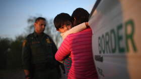 A one-year-old from El Salvador clings to his mother after she turned themselves in to Border Patrol agents on December 7, 2015 near Rio Grande City, Texas. (John Moore/Getty Images)