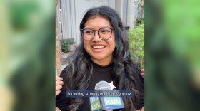 A college art student smiling on camera with the caption "I'm feeling so many emotions right now"