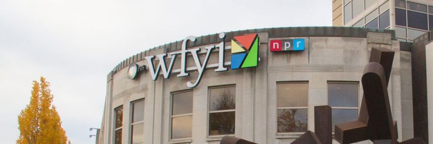 Picture of front entrance zoomed in on the PBS WFYI and NPR logo signs