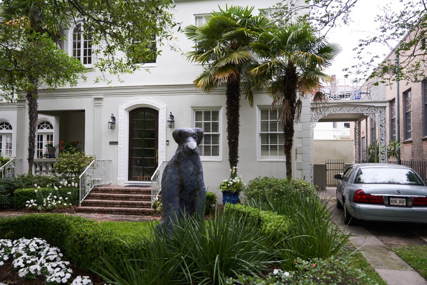 A dog statue wears a mask at a home on St Charles Avenue in New Orleans, Louisiana. April 7, 2020.