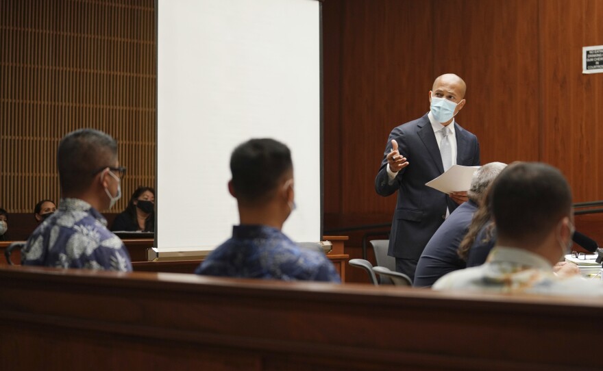 Defense attorney Thomas Otake, standing, looks over toward defendants Honolulu Police Department Officers Geoffrey Thom, left, Christopher Fredeluces, center, and Zackary Ah Nee, right, in Judge William Domingo's courtroom, Tuesday, July 20, 2021, in Honolulu. (Cory Lum/Honolulu Civil Beat via AP, Pool)