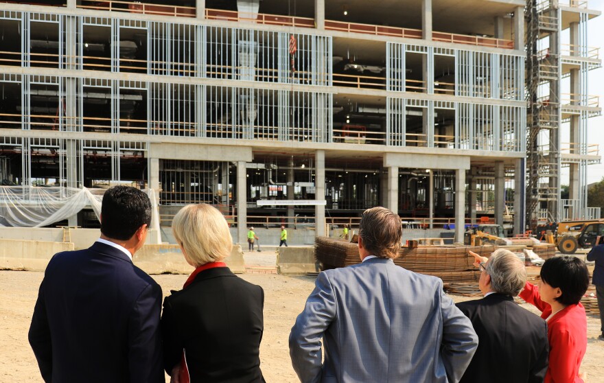 From left, JobsOhio CEO JP Nauseef, Ohio State President Kristina Johnson, Ohio Lt. Gov. Jon Husted, Ohio Gov. Mike DeWine and Ohio State Vice President for Research, Innovation and Knowledge Grace Wang watching the final beam go up on a building in the university's Innovation District.