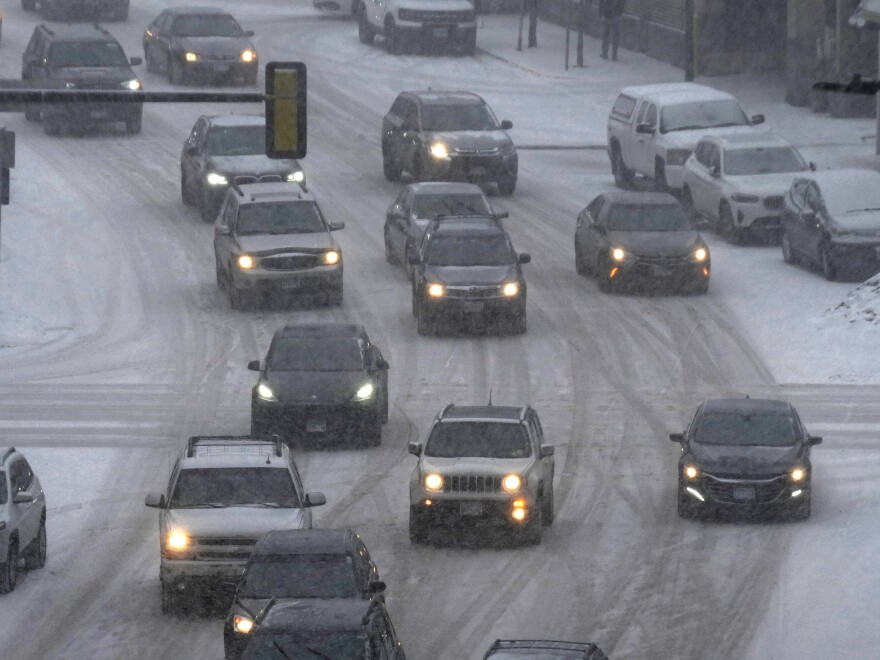 Vehicles drive in downtown Minneapolis as snow falls Tuesday. A winter storm took aim at the Upper Midwest on Tuesday, threatening to bring blizzard conditions, bitterly cold temperatures and 2 feet of snow.