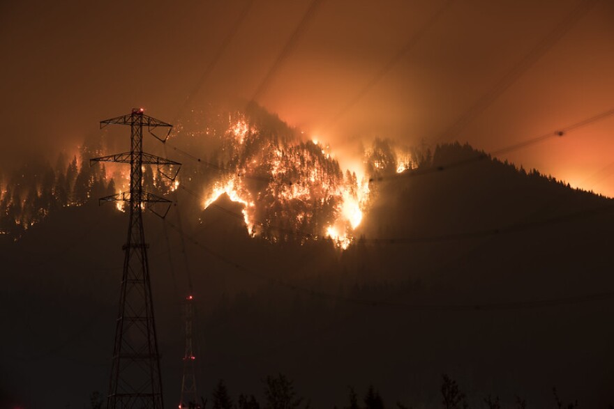 A wildfire burns near power lines. Researchers at Washington State University hope a National Science Foundation Grant will help them better plan for power outages related to wildfires. (Credit: Curtis Gregory Perry / Flickr Creative Commons)