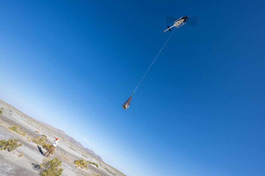 On Scene Commander of Recovery Jasmine Nakayama attaches the sample return capsule from NASA’s OSIRIS-REx mission to a helicopter for transport to the cleanroom, Sunday, Sept. 24, 2023, shortly after the capsule landed at the Department of Defense's Utah Test and Training Range. The sample was collected from the asteroid Bennu in October 2020 by NASA’s OSIRIS-REx spacecraft.