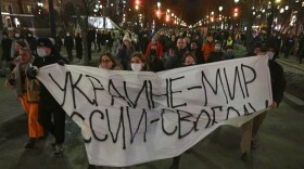 Demonstrators march with a banner that reads: "Ukraine - Peace, Russia - Freedom," in Moscow, Russia, Thursday, Feb. 24. (Dmitry Serebryakov/AP Photo)