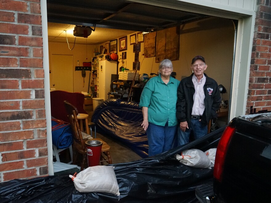 John and Louise Hutchins stand in their garage in Fort Smith, Ark., behind a homemade sandbag barrier. They chose not to evacuate, in part because they did not think their neighborhood would flood.