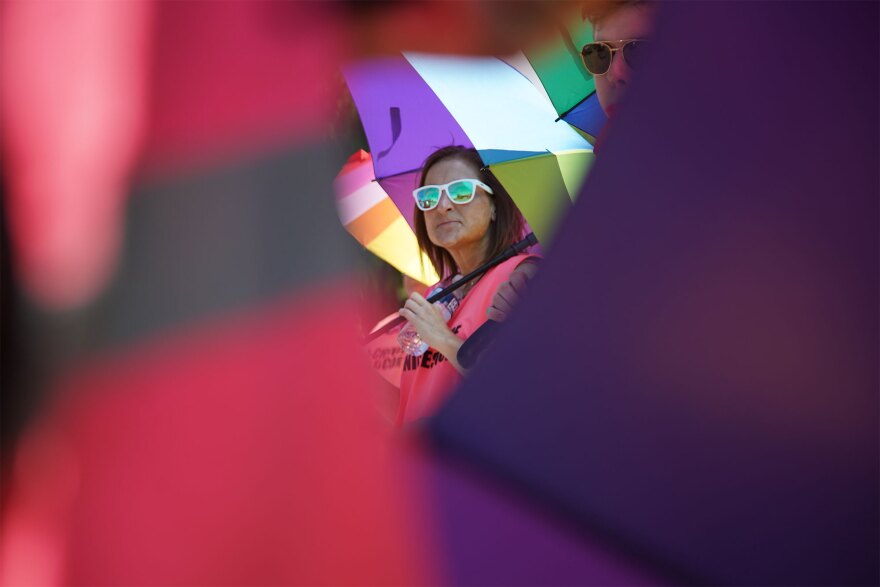 Diane Francis, of Stow, holds an umbrella alongside fellow clinic escorts on Friday. This was her first day volunteering as a clinic escort, she said.