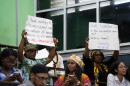 FILE - People hold signs during a speech by Charles Gladstone, a descendant of former plantation owner John Gladstone, as he delivers an apology on behalf of the Gladstone family at Georgetown University in Georgetown, Guyana, Friday, Aug. 25, 2023.