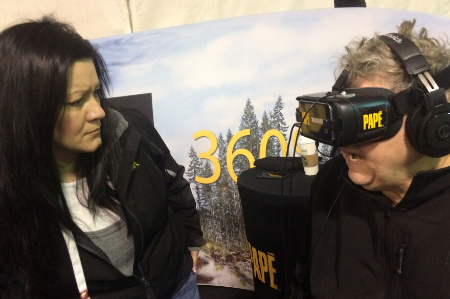 PapÃ¨ 360 technician Christine Cantamessa (L) asks retired logger Jack Abernathy what he sees through the virtual reality goggles.