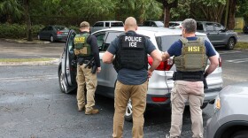 federal officials outside a car  