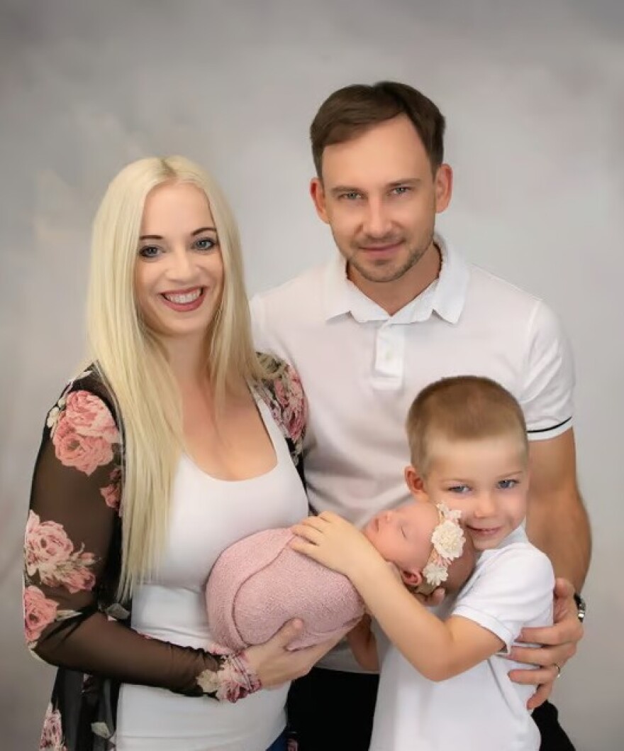 Man and woman and little boy all hold baby 