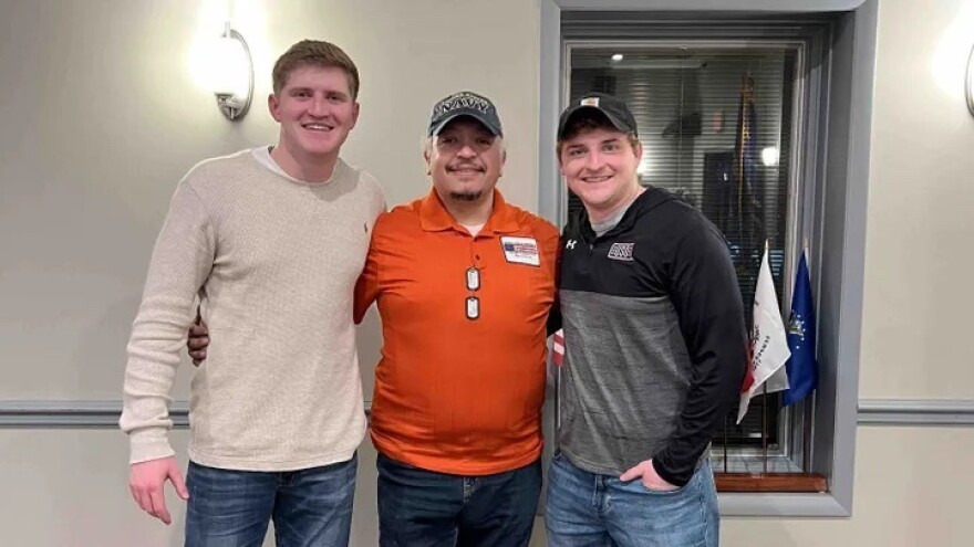 Three men locked in arms smiling for the camera